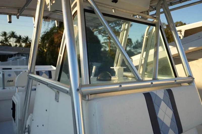 Slide: The Image of 1999 Regulator 26 Forward Seating boat with aluminum frame and windshield, docked outdoors. - 12