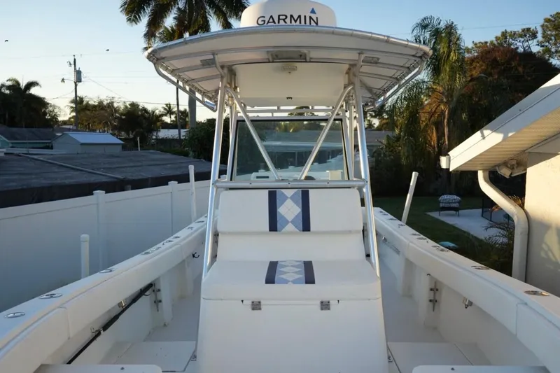 Slide: The Image of 1999 Regulator 26 Forward Seating boat with Garmin equipment, docked near palm trees. - 13
