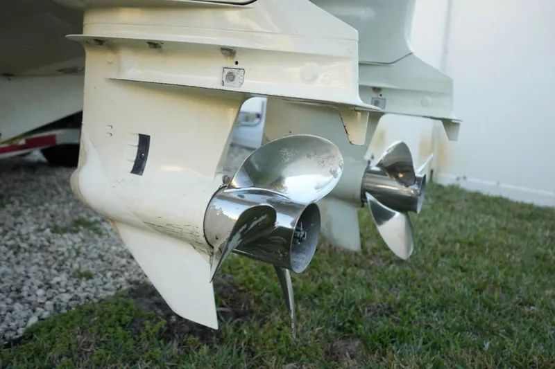 Slide: The Image of Twin propellers of a 1999 Regulator 26 Forward Seating boat on grass. - 21