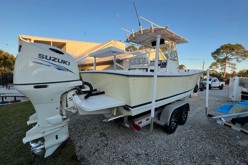 Slide: The Image of 1999 Regulator 26 Forward Seating boat with Suzuki outboard motor on trailer. - 22
