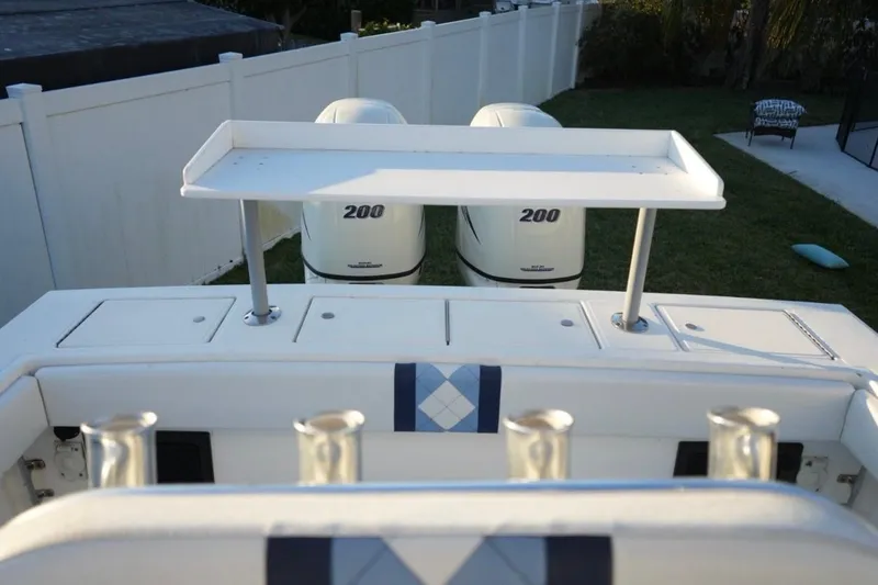 Slide: The Image of 1999 Regulator 26 Forward Seating boat with twin 200 horsepower engines, docked in a yard. - 5