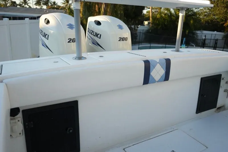 Slide: The Image of 1999 Regulator 26 Forward Seating boat with twin Suzuki 200 engines, docked outdoors. - 6