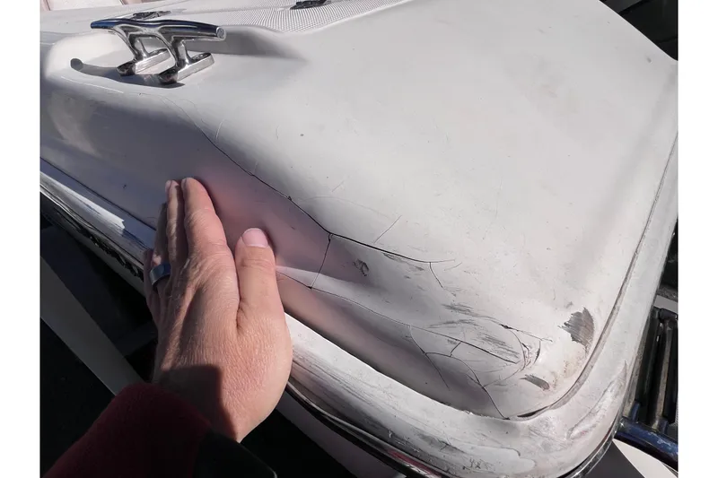 Slide: The Image of Hand inspecting damage on 2008 Scout 205 Dorado boat surface. - 12