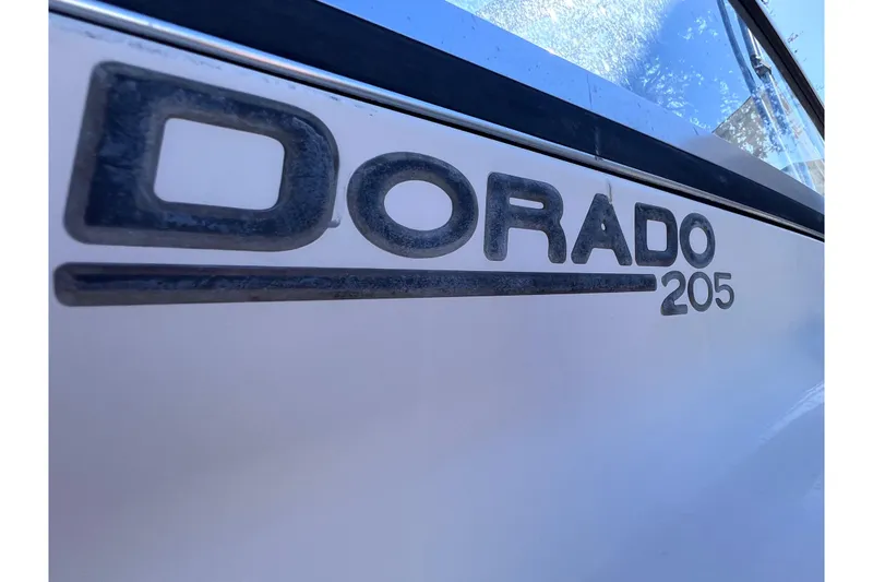 Slide: The Image of Close-up of 2008 Scout 205 Dorado boat logo on white surface. - 14