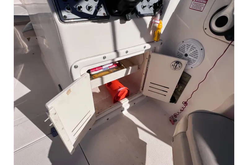 Slide: The Image of Open storage compartment on 2008 Scout 205 Dorado boat with safety equipment and supplies. - 22