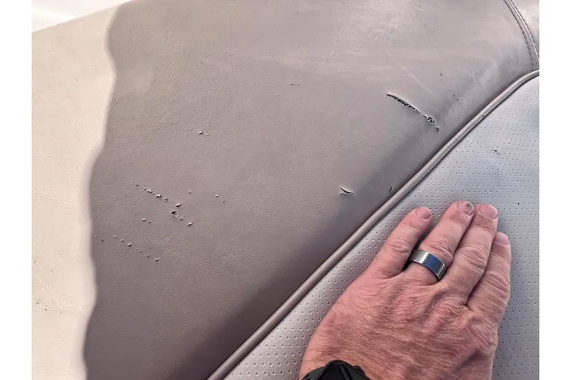Slide: The Image of Worn upholstery on 2008 Scout 205 Dorado boat seat with visible hand for scale. - 30