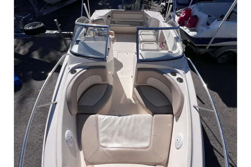 Slide: The Image of 2008 Scout 205 Dorado boat interior with seating and windshield, docked outdoors. - 34