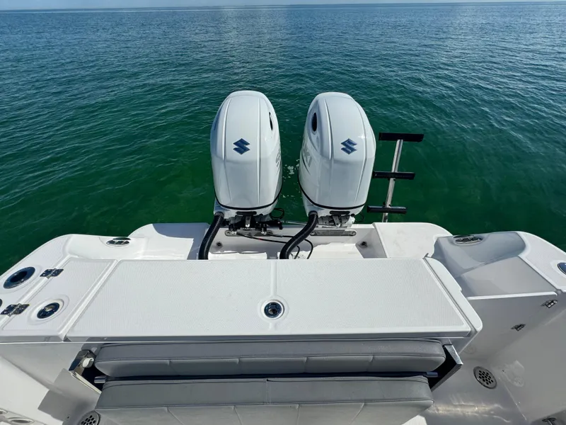 Slide: The Image of 2022 Aquasport 2500 Center Console with twin outboard engines on open water. - 10