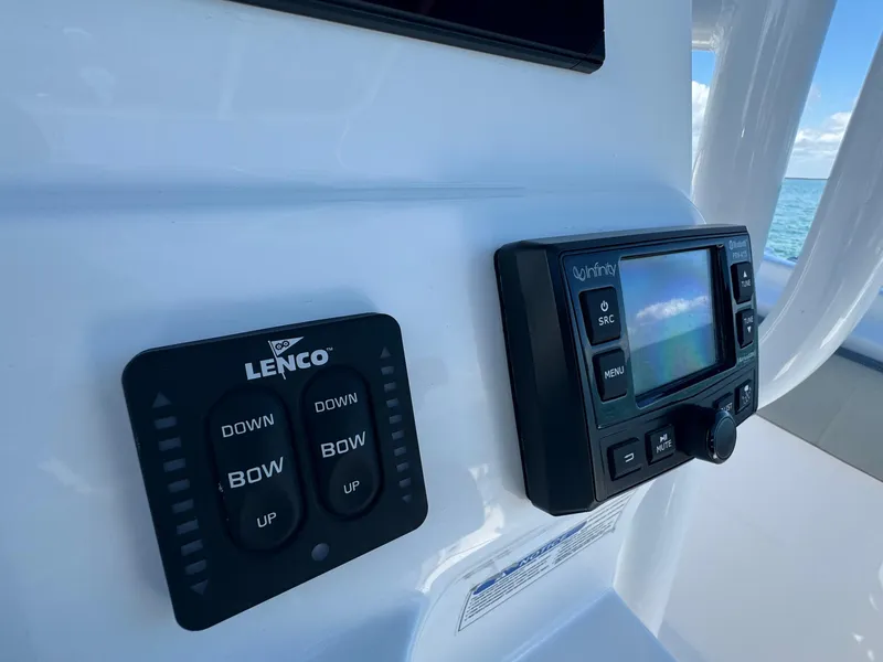 Slide: The Image of 2022 Aquasport 2500 Center Console control panel with Lenco trim tab switches and display screen. - 24