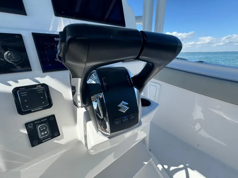 Slide: The Image of 2022 Aquasport 2500 Center Console boat controls and throttle on a sunny day. - 25