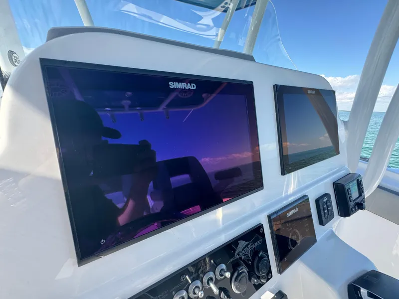Slide: The Image of 2022 Aquasport 2500 Center Console dashboard with Simrad displays. - 28