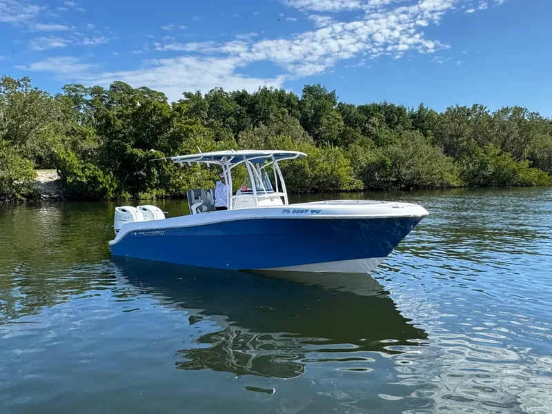 Slide: The Image of 2022 Aquasport 2500 Center Console boat on calm water with lush greenery in the background. - 3