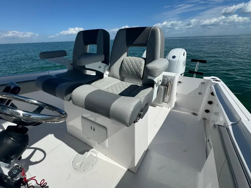Slide: The Image of 2022 Aquasport 2500 Center Console boat interior with dual seats on open water. - 32