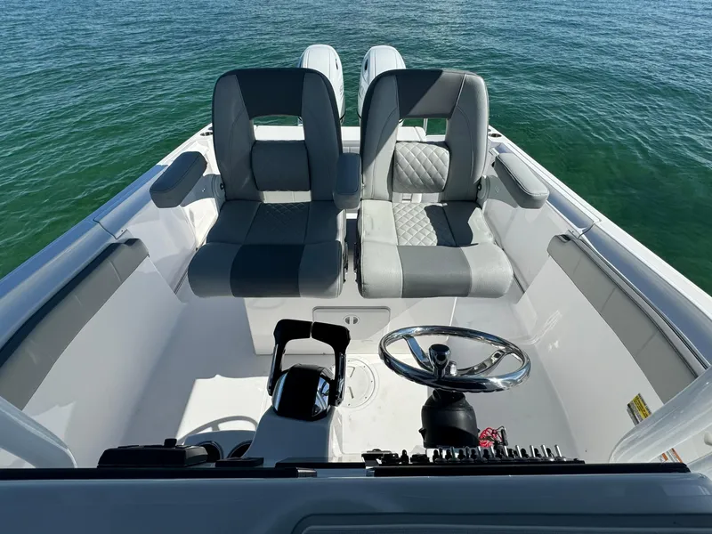 Slide: The Image of 2022 Aquasport 2500 Center Console boat interior with dual seats and steering wheel. - 33