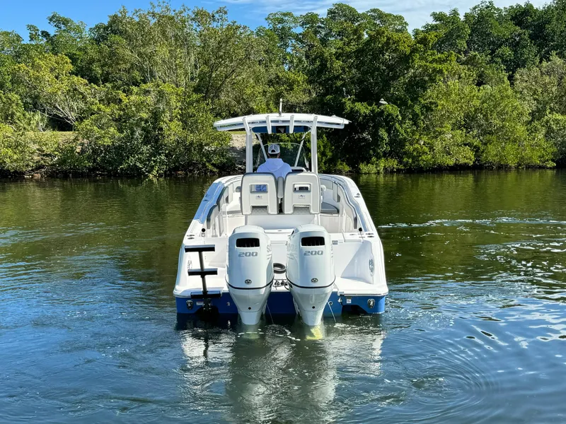 Slide: The Image of 2022 Aquasport 2500 Center Console boat with twin engines on a calm river. - 7