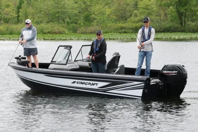 Slide: The Image of Three people fishing on a 2026 Starcraft Titan 186 boat in a serene lake. - 7