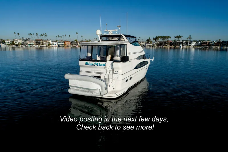 Slide: The Image of 2004 Carver 466 Motor Yacht cruising on open water under clear blue skies. - 2