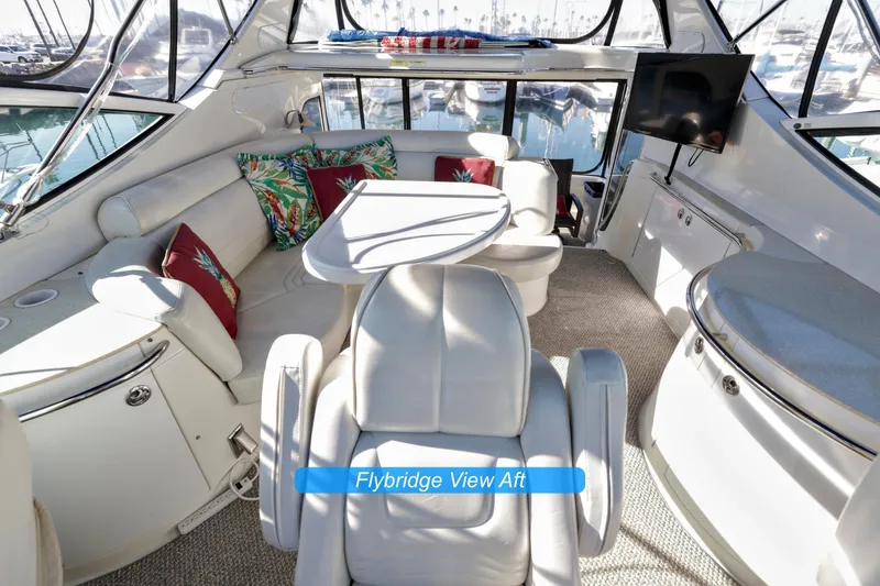 Slide: The Image of 2004 Carver 466 Motor Yacht interior with chairs and table, overlooking water. - 11