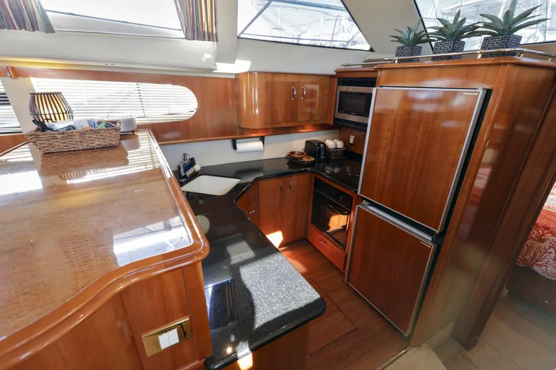 Slide: The Image of Luxurious kitchen interior of 2004 Carver 466 Motor Yacht with wood cabinetry and modern appliances. - 17