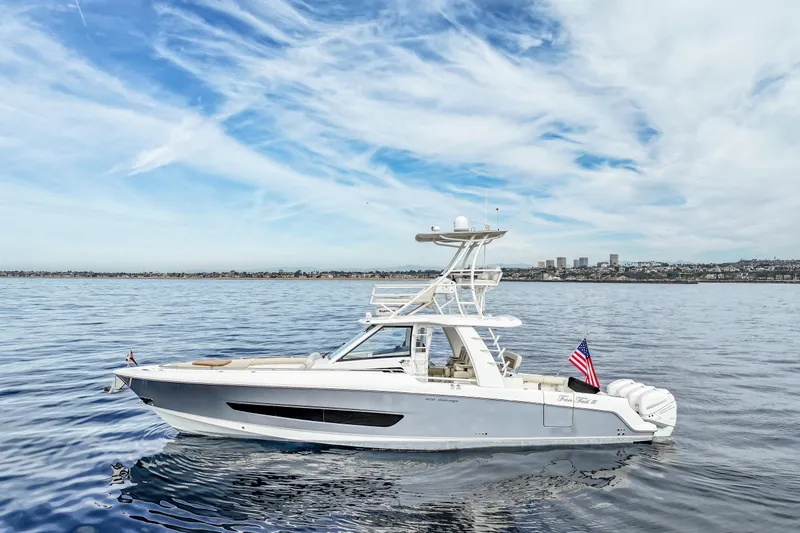 The Image of 2018 Boston Whaler 420 Outrage boat on calm ocean with city skyline background. - 0