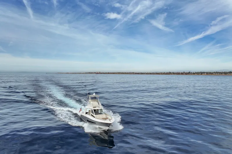 Slide: The Image of 2018 Boston Whaler 420 Outrage cruising on open water under a clear sky. - 13