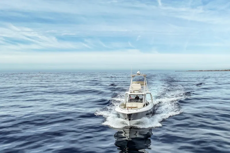 Slide: The Image of 2018 Boston Whaler 420 Outrage cruising on open water under a clear sky. - 14