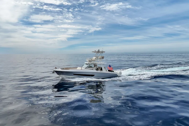 Slide: The Image of 2018 Boston Whaler 420 Outrage cruising on open ocean under blue sky. - 16