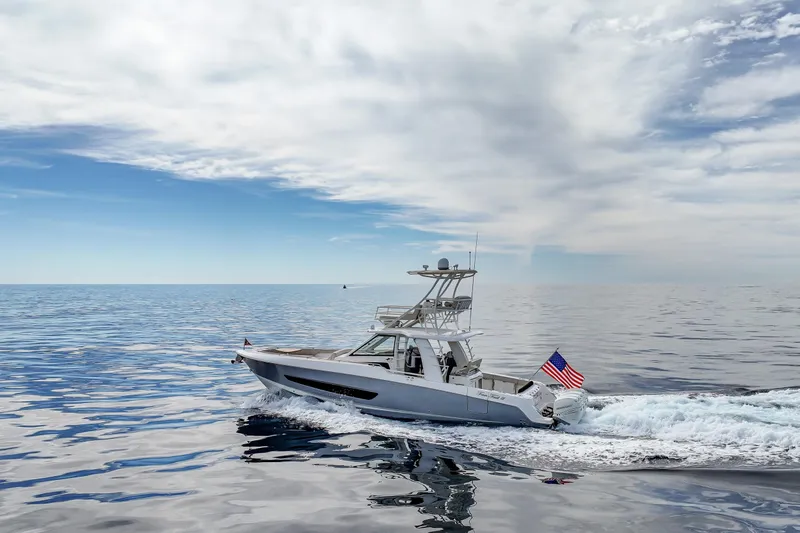 Slide: The Image of 2018 Boston Whaler 420 Outrage cruising on open sea under a cloudy sky. - 17