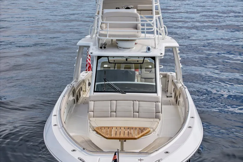 Slide: The Image of 2018 Boston Whaler 420 Outrage boat on calm water, showcasing luxury seating and design. - 18