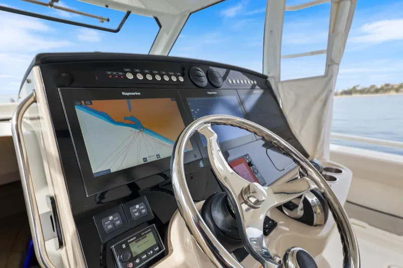 Slide: The Image of 2018 Boston Whaler 420 Outrage helm with navigation display and steering wheel. - 23