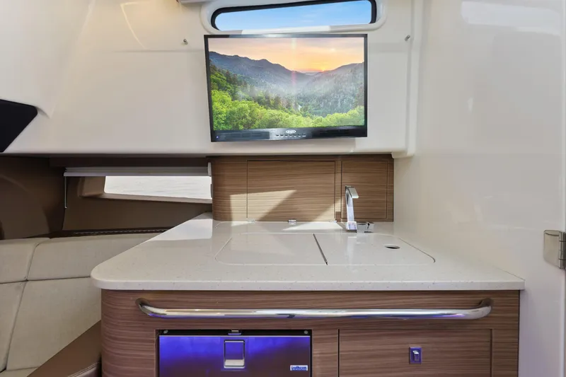Slide: The Image of Interior of 2018 Boston Whaler 420 Outrage with modern kitchenette and mounted TV. - 37