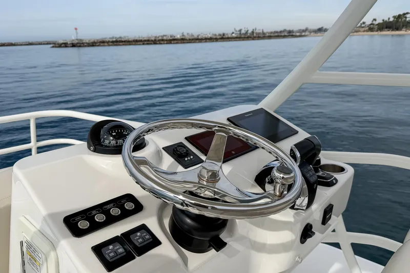 Slide: The Image of 2018 Boston Whaler 420 Outrage helm with steering wheel and navigation controls. - 45