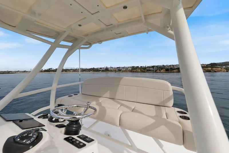 Slide: The Image of 2018 Boston Whaler 420 Outrage helm with seating, overlooking serene coastal waters. - 46