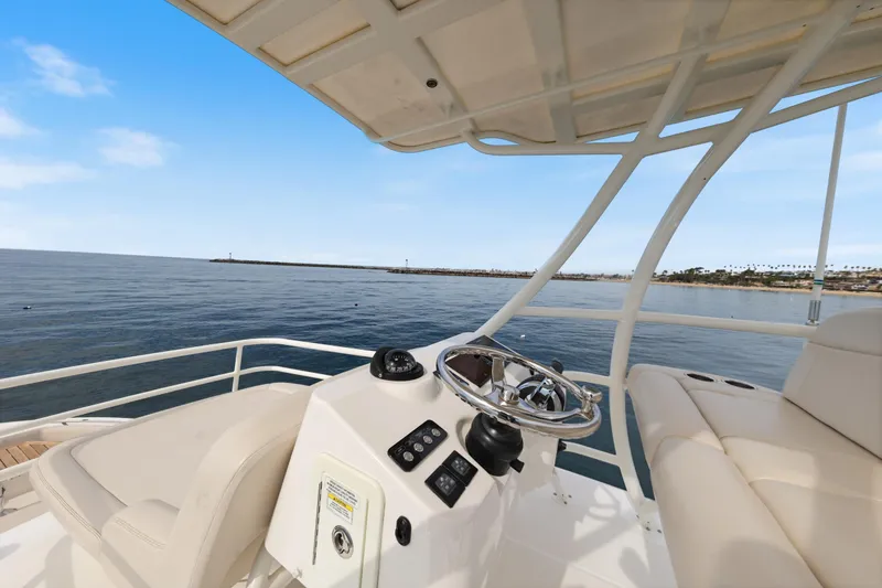 Slide: The Image of 2018 Boston Whaler 420 Outrage helm with ocean view, featuring luxurious seating and controls. - 47