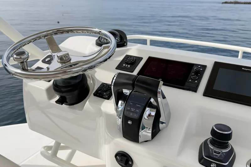 Slide: The Image of Control panel of a 2018 Boston Whaler 420 Outrage boat with steering wheel and navigation screens. - 49