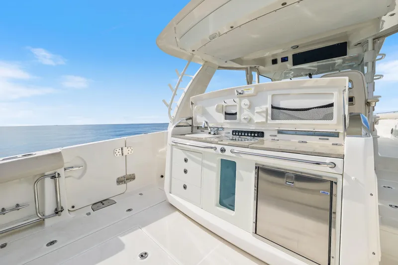 Slide: The Image of 2018 Boston Whaler 420 Outrage boat deck with sleek kitchen setup, ocean view. - 54