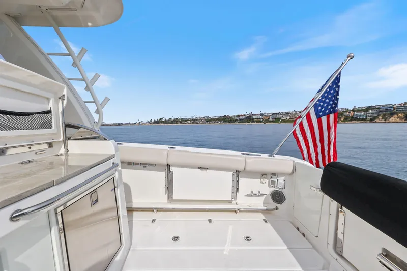 Slide: The Image of 2018 Boston Whaler 420 Outrage boat deck with American flag, ocean view. - 56