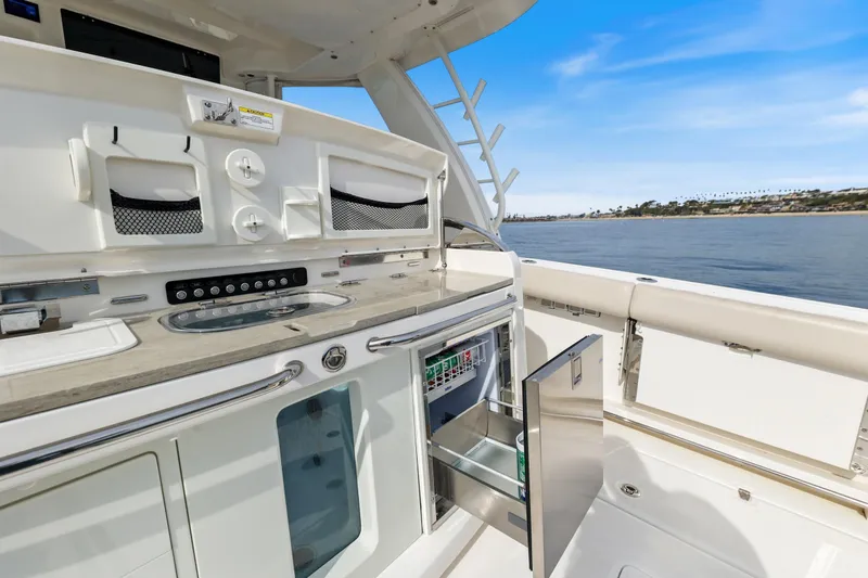 Slide: The Image of 2018 Boston Whaler 420 Outrage boat interior with open storage and ocean view. - 59