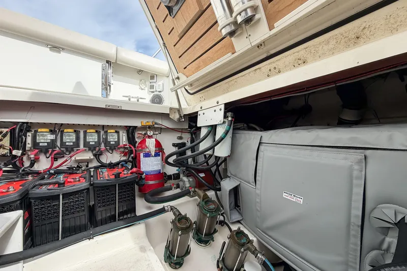 Slide: The Image of 2018 Boston Whaler 420 Outrage engine compartment with batteries and fire extinguisher. - 70