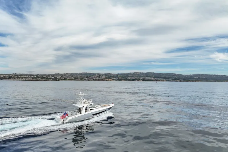 Slide: The Image of 2018 Boston Whaler 420 Outrage cruising on calm waters under a cloudy sky. - 8