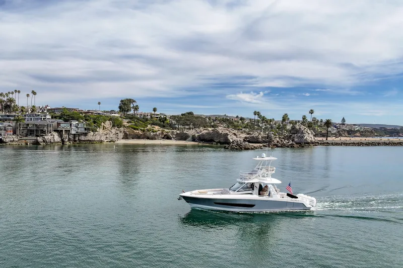 Slide: The Image of 2018 Boston Whaler 420 Outrage cruising near scenic coastal landscape. - 80