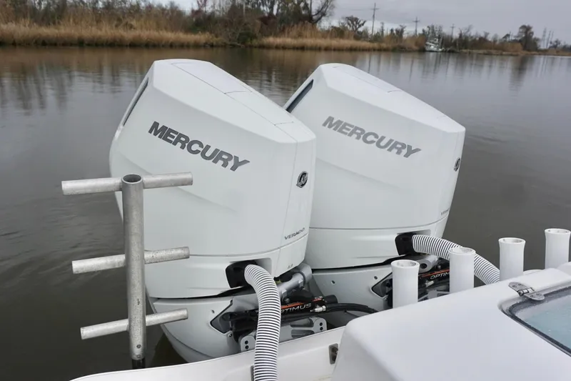 Slide: The Image of Twin Mercury outboard engines on a 2023 Cape Horn 34 XS boat, docked on a calm river. - 18