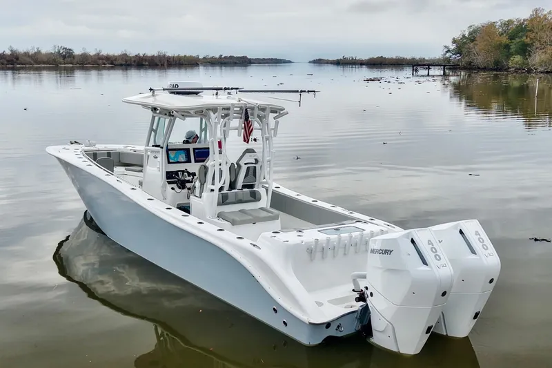 Slide: The Image of 2023 Cape Horn 34 XS boat with dual Mercury engines on a calm lake. - 2