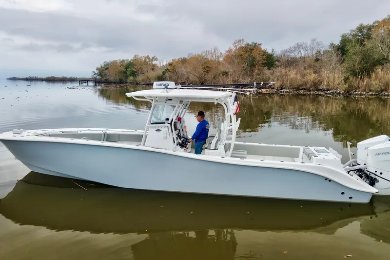 Slide: The Image of 2023 Cape Horn 34 XS boat on calm water, surrounded by autumn trees. - 5