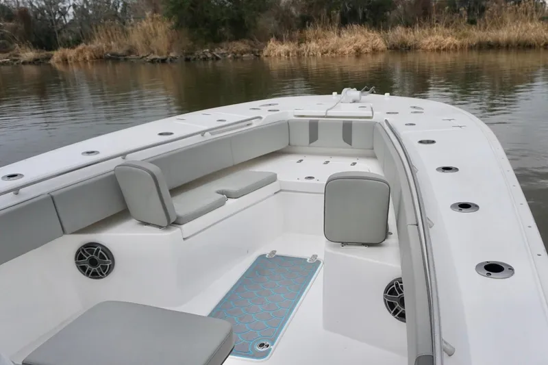 Slide: The Image of 2023 Cape Horn 34 XS boat interior with seating and speakers on calm water. - 9