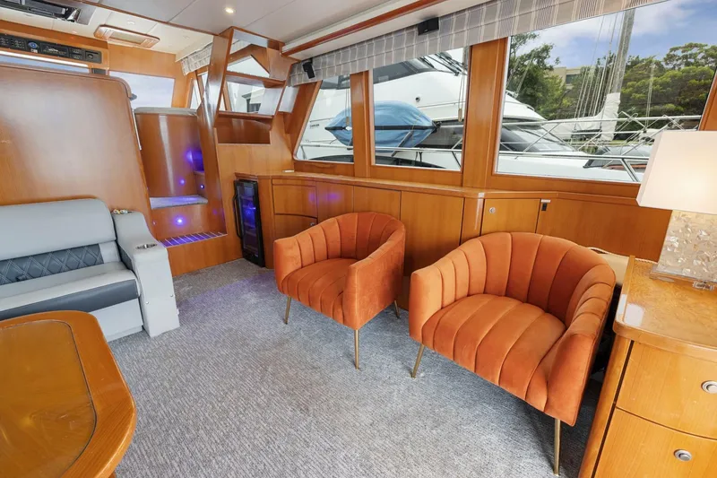 Slide: The Image of Luxurious yacht interior with orange chairs, wood paneling, and large windows, Symbol 58, 2002 model. - 10