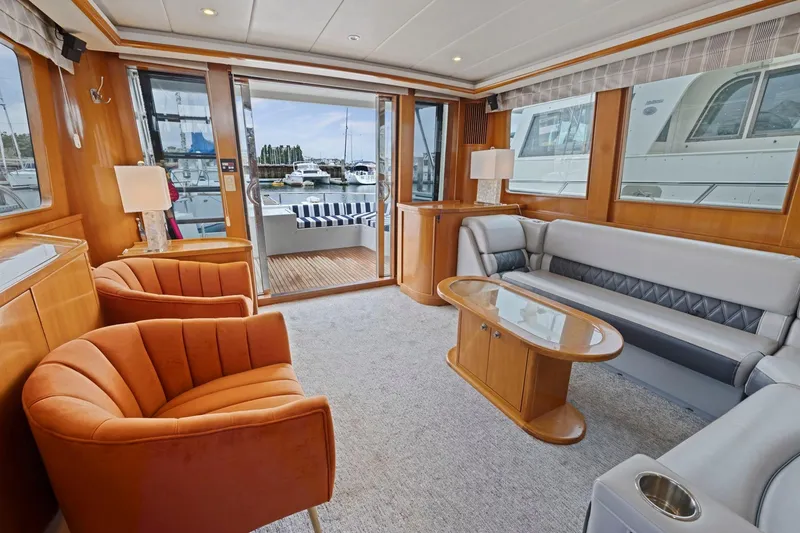 Slide: The Image of Luxurious yacht interior with orange chairs, gray sofa, and marina view, Symbol 58, 2002 model. - 11