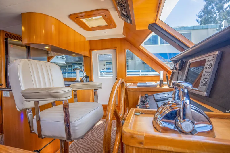 Slide: The Image of Interior of a 2002 Symbol 58 yacht, featuring helm and seating. - 22