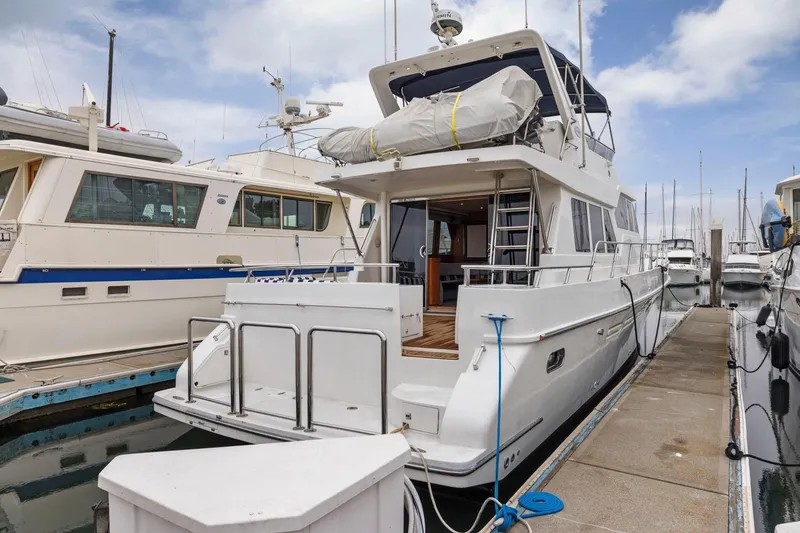 Slide: The Image of Luxury Symbol 58 yacht docked at marina, 2002 model, with clear blue sky. - 37