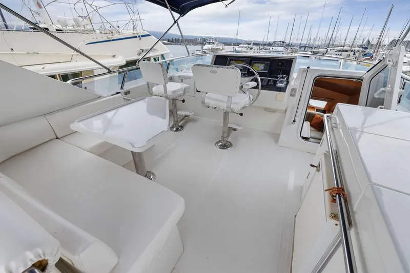 Slide: The Image of Luxurious 2002 Symbol 58 yacht cockpit with seating, table, and helm at marina. - 40